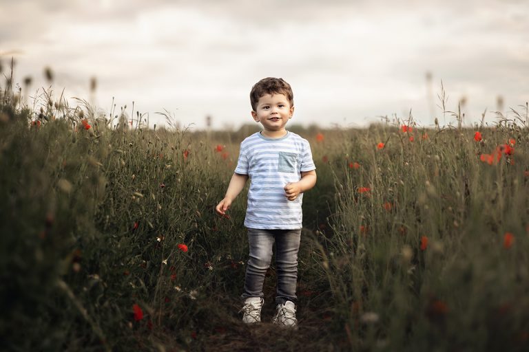 Kleiner Junge rennt durch ein Mohnblumenfeld - Outdoor Kinderfoto geshootet von Sanja Balceva